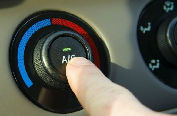  A mechanic servicing a car's air conditioning system, inspecting parts and recharging refrigerant for efficient operation.